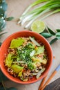 Bowl of stir fried udon noodles garnished with black sesame seeds and fresh mint with green chopsticks Royalty Free Stock Photo