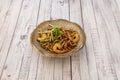 Bowl of stir-fried udon noodles with shrimps and vegetables on wooden table Royalty Free Stock Photo