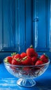 A bowl of strawberries on a blue table Royalty Free Stock Photo