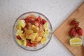 A bowl of strawberries, a lemon and brown sugar.