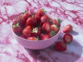 A bowl of strawberries on a pink background. The bowl is full of strawberries and they are all Royalty Free Stock Photo
