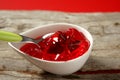 Bowl of strawberry red sweet jelly and green spoon Royalty Free Stock Photo