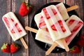 Bowl of strawberry vanilla yogurt popsicles on dark wood Royalty Free Stock Photo