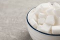 Bowl with sugar cubes on grey table, closeup. Space for text Royalty Free Stock Photo