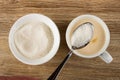 Bowl with sugar, spoon with sugar above white cup with fermented baked milk on table. Top view Royalty Free Stock Photo