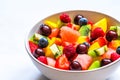Bowl of summer fruit and berry salad on white marble background. healthy vegan food Royalty Free Stock Photo