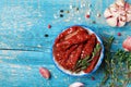 Bowl of sun dried tomatoes with herbs and olive oil on teal wooden table top view. Royalty Free Stock Photo