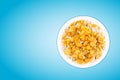 Bowl of sweet cornflakes with milk on blue background, top view Royalty Free Stock Photo