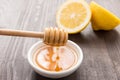 Bowl of sweet honey and lemons on wooden table Royalty Free Stock Photo