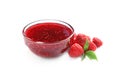 Bowl of sweet jam with ripe raspberries and green leaves Royalty Free Stock Photo