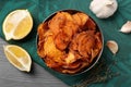 Bowl of sweet potato chips with lemon and garlic on table Royalty Free Stock Photo