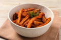 Bowl with sweet potato fries and rosemary on wooden table, closeup Royalty Free Stock Photo