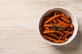 Bowl with sweet potato fries and rosemary on wooden table, top view. Space for text Royalty Free Stock Photo