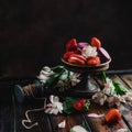 bowl with sweets macarons and strawberries on wooden table