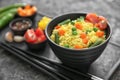 Bowl with tasty boiled rice and vegetables on grunge table, closeup Royalty Free Stock Photo