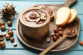Bowl of tasty chocolate paste with hazelnuts on light blue wooden table Royalty Free Stock Photo