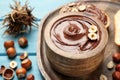 Bowl of tasty chocolate paste with hazelnuts on light blue wooden table, space for text Royalty Free Stock Photo