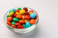 Bowl with tasty colorful candies on white wooden table, closeup Royalty Free Stock Photo
