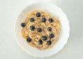 Bowl with tasty cooked oatmeal porridge with banana and fresh blueberries. Healthy breakfast every morning. Healthy lifestyle and Royalty Free Stock Photo