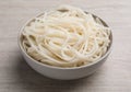 Bowl of tasty cooked rice noodles on white wooden table Royalty Free Stock Photo