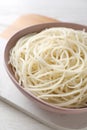 Bowl of tasty cooked rice noodles on white wooden table, closeup Royalty Free Stock Photo