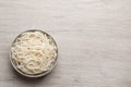 Bowl of tasty cooked rice noodles on white wooden table, top view. Space for text Royalty Free Stock Photo