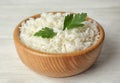 Bowl with tasty cooked rice and parsley on white table, closeup Royalty Free Stock Photo