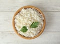 Bowl with tasty cooked rice and parsley on wooden table, top view Royalty Free Stock Photo