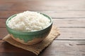 Bowl of tasty cooked white rice on wooden table Royalty Free Stock Photo