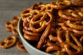 Bowl with tasty cracker pretzels on gray table, close up