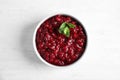 Bowl of tasty cranberry sauce with sauce on white wooden background Royalty Free Stock Photo