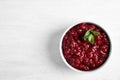 Bowl of tasty cranberry sauce with sauce on white wooden background, top view Royalty Free Stock Photo