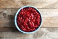 Bowl of tasty cranberry sauce on wooden background Royalty Free Stock Photo