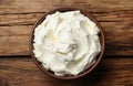 Bowl of tasty cream cheese on wooden table, top view Royalty Free Stock Photo