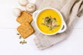 Bowl of Tasty Homemade Pumpkin Cream Soup decotated with Mushrooms and Pumpkin Seeds White Wooden Background View from Above