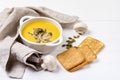 Bowl of Tasty Homemade Pumpkin Cream Soup decotated with Mushrooms and Pumpkin Seeds White Wooden Background View from Above