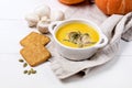 Bowl of Tasty Homemade Pumpkin Cream Soup decotated with Mushrooms and Pumpkin Seeds White Wooden Background View from Above