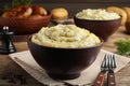 Bowl of tasty mashed potatoes with black pepper served on wooden table