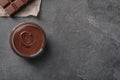 Bowl with tasty melted chocolate on grey table, top view Royalty Free Stock Photo