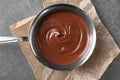 Bowl with tasty melted chocolate on grey table, top view Royalty Free Stock Photo