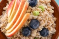 Bowl with tasty oatmeal, berries and fruit, closeup