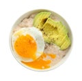 Bowl with tasty oatmeal, fried egg and sliced avocado on white background