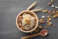 Bowl with tasty oatmeal, raisins and nuts on grey background