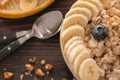 Bowl with tasty oatmeal, sliced banana and fresh berries on wooden table, closeup Royalty Free Stock Photo
