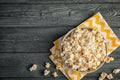 Bowl of tasty popcorn on wooden background, top view