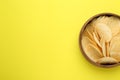 Bowl of tasty potato chips on yellow background, top view. Space for text Royalty Free Stock Photo