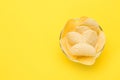 Bowl of tasty potato chips on yellow background, top view. Space for text Royalty Free Stock Photo