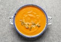 Bowl with tasty pumpkin soup on gray background