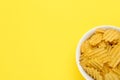 Bowl of tasty ridged potato chips on yellow background, top view. Space for text Royalty Free Stock Photo