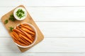 Bowl with tasty sweet potato fries and sauce on wooden background, top view Royalty Free Stock Photo